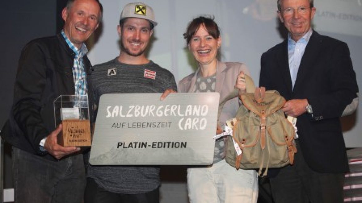 Vier lächelnde Menschen halten auf einer Bühne Preise und ein Schild mit der Aufschrift SalzburgerLand Card Platin-Edition.