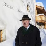 Älterer Mann in Mantel und Hut steht vor einem verschneiten Gebäude mit der Aufschrift Bergbau- und Gotikmuseum.