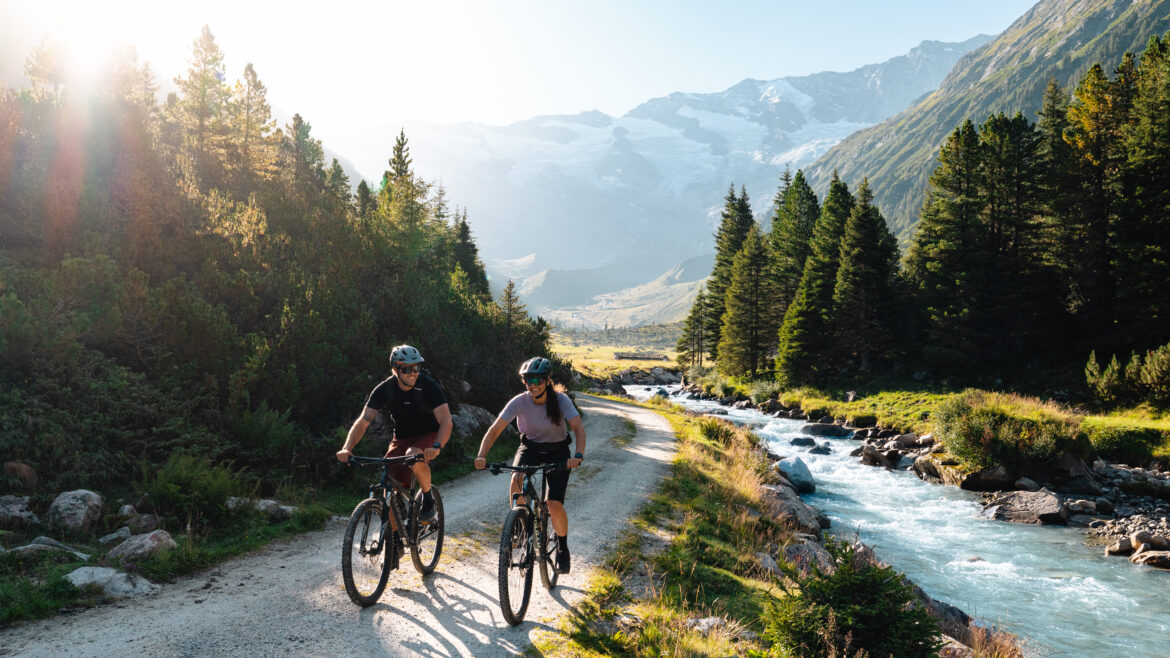 Zwei Radfahrer radeln entlang der Krimmler Ache