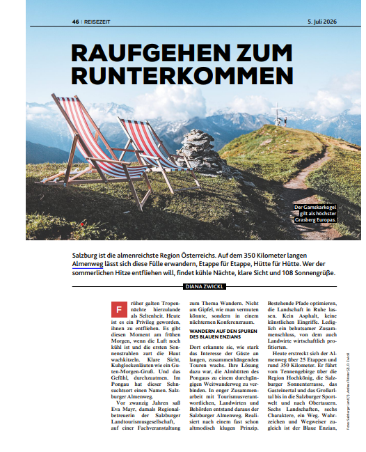 Zwei gestreifte Liegestühle stehen auf einem grasbewachsenen Felsvorsprung in den Bergen, im Hintergrund sind Alpengipfel und Wolken zu sehen.