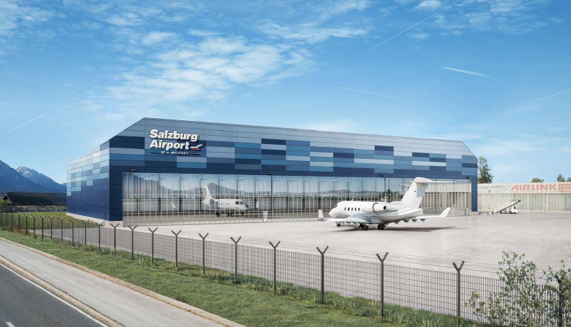 Moderner blauer Hangar am Flughafen Salzburg, vor dem zwei kleine Jets geparkt sind, umgeben von einem Zaun.